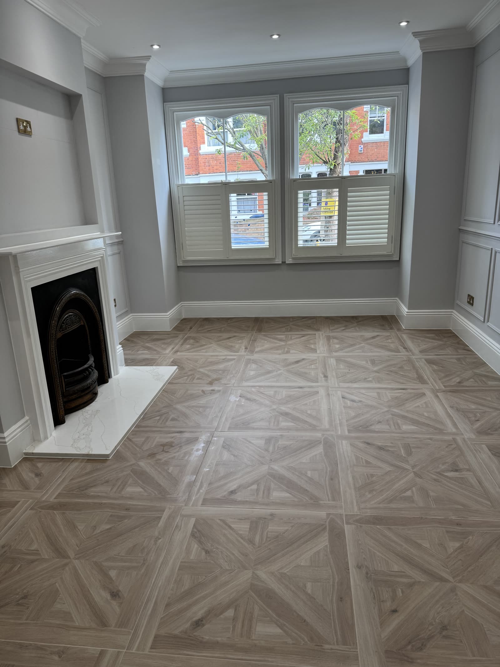 Hallway with parquet feature wall, bench seat and sash window.