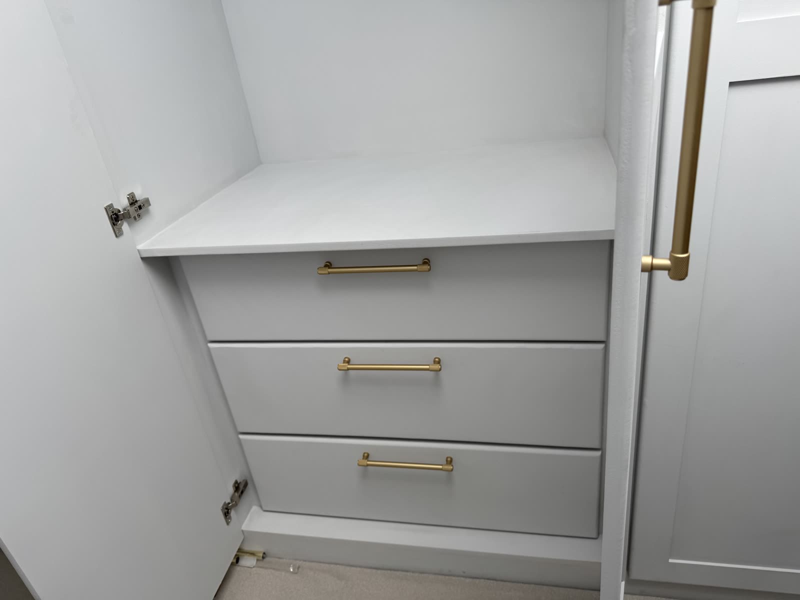 Bespoke joinery detail — built-in drawers with brushed brass bar handles.