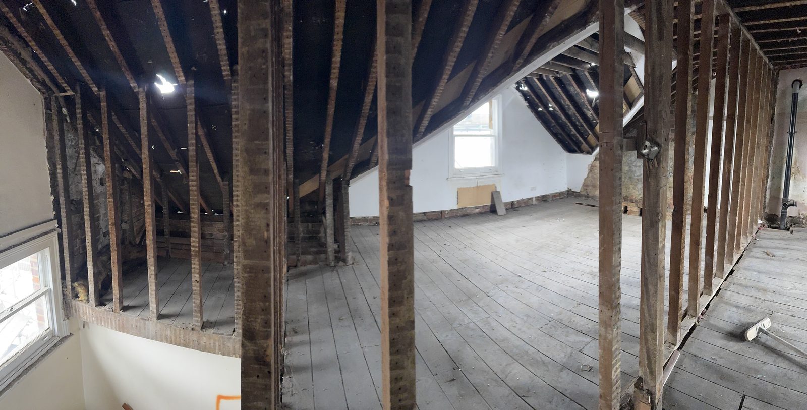 Upper floor opened up to expose joists and steel props during the structural strip-out — before.